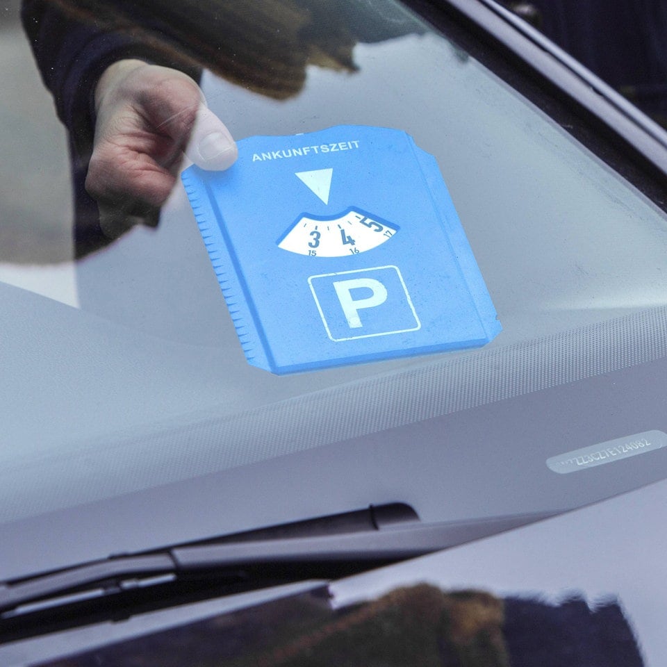Elektronische Parkscheibe, PKW mit einer digitalen Uhr, die die Ankunft des  Fahrzeugs auf einem Parkplatz anzeigt