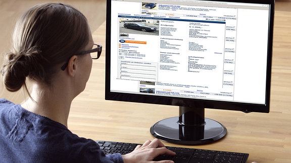 Eine Frau sucht auf einem Online-Portal für Gebrauchtwagen