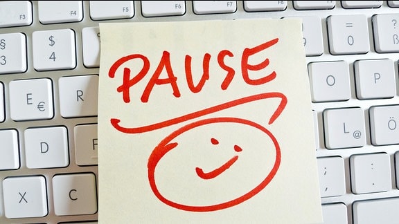 "Pause" steht auf einem Zettel, der auf einer Tastatur liegt