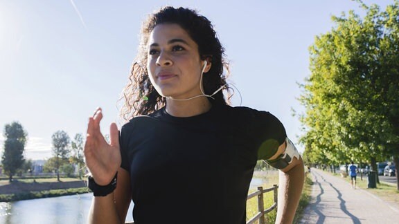Eine Frau joggt mit Kopfhörern