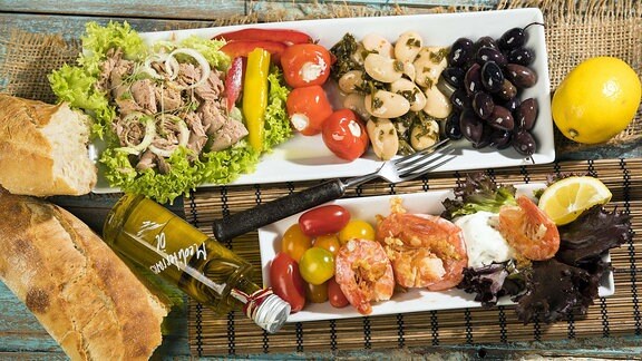Antipasti, Thunfisch, Salat, gefüllte Paprika, Pfefferoni, große Bohnen, schwarze Oliven, Garnelen, Sour Creme, Tomaten und Weißbrot
