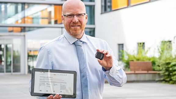 Ein Mann hält ein Tablet einen Tracker - Dr. Stefan Moritz von der Universitätsmedizin Halle/S.